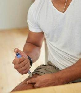 a man sitting on the floor looking at a cell phone