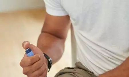 a man sitting on the floor looking at a cell phone