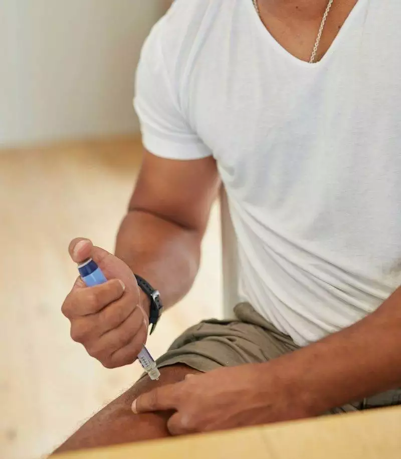 a man sitting on the floor looking at a cell phone
