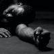a man laying on the ground with his hands on his knees