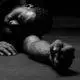 a man laying on the ground with his hands on his knees