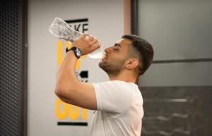 Man drinking water from bottle in gym